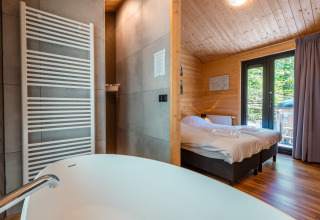 Moderne Wellness Lodge «Wood XL» met bad en slaapkamer bij Holiday park De Wiltzangh in Nederland.