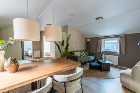 Helles, modernes Wohnzimmer in der Heidelodge im Ferienpark De Wiltzangh, Niederlande, mit Essbereich und Sofa.