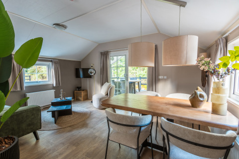Interno elegante della tiny house Heidelodge al Holiday park De Wiltzangh, con sala da pranzo e soggiorno.