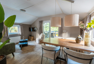 Stijlvol interieur van tiny house Heidelodge op vakantiepark De Wiltzangh, met eet- en zithoek.
