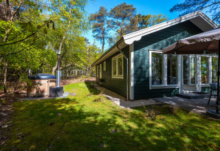 Fins chalet op vakantiepark De Wiltzangh in Nederland, met terras, buitenspa en omringd door natuur.