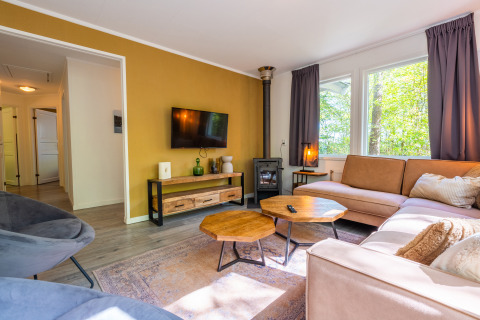 Sala luminosa en Finnish Chalet en Holiday park De Wiltzangh, Países Bajos, con decoración moderna y grandes ventanales.