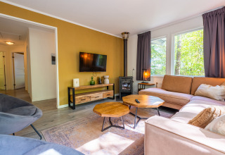 Lichte woonkamer in het Finnish Chalet op Holiday park De Wiltzangh, Nederland, met moderne inrichting en grote ramen.
