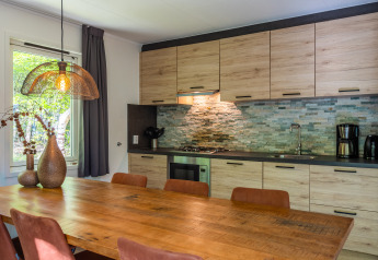 Moderne køkken og spisestue i den finske chalet ved Holiday park De Wiltzangh i Holland, med træmøbler.