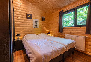 Cozy wooden bedroom at Hackfort lodge, Holiday park De Wiltzangh, Netherlands, featuring twin beds.