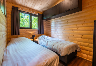 Camera con due letti singoli in un lodge di legno presso Hackfort, Holiday park De Wiltzangh, Paesi Bassi.