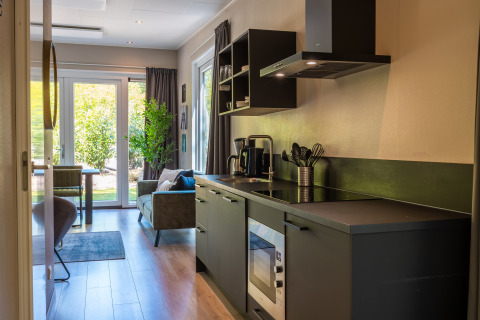 Moderne lodgekeuken en woonkamer met tuinzicht bij Just Nature, Holiday park De Wiltzangh, Nederland.