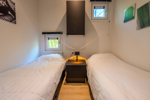 Due letti singoli con comodino nel lodge Just Nature, Holiday park De Wiltzangh nei Paesi Bassi.
