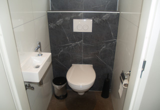 Baño moderno con inodoro y lavabo en una cabaña Just Nature en Holiday park De Wiltzangh, Países Bajos.