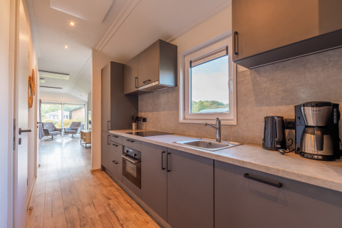 Modern Velthorst lodge at Holiday park Aan de Maas, Netherlands, featuring a stylish kitchen and lounge area.
