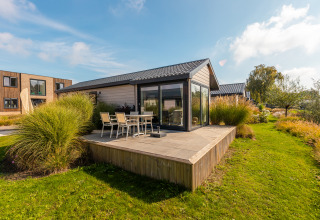 Modern tiny house 'Velthorst' at Holiday park Aan de Maas in the Netherlands with patio and garden.