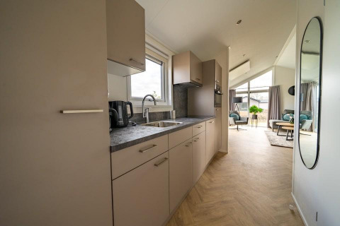Cucina e soggiorno moderni di una tiny house Velthorst a Holiday park Aan de Maas, Paesi Bassi.