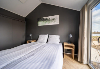 Moderne, kompakt soveværelse i tiny house Velthorst ved Holiday park Aan de Maas, Nederlandene.