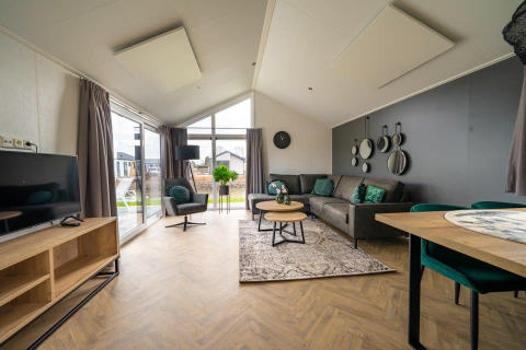 Zona giorno luminosa in una tiny house Velthorst al Holiday park Aan de Maas, Paesi Bassi, arredamento moderno.