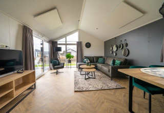 Espace salon lumineux d’une tiny house Velthorst au Holiday park Aan de Maas aux Pays-Bas, déco moderne.