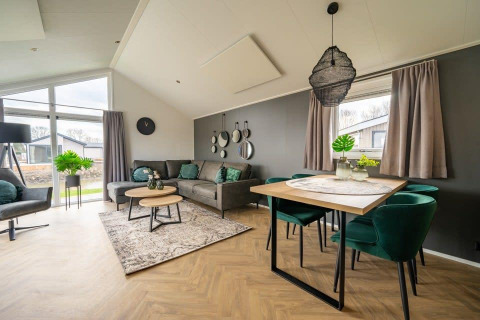 Salón moderno y luminoso en la tiny house Velthorst en Holiday park Aan de Maas, Países Bajos, con decoración elegante.