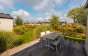 View from a terrace near lodge Berkel at Holiday park Aan de Maas, Netherlands, featuring table and chairs.