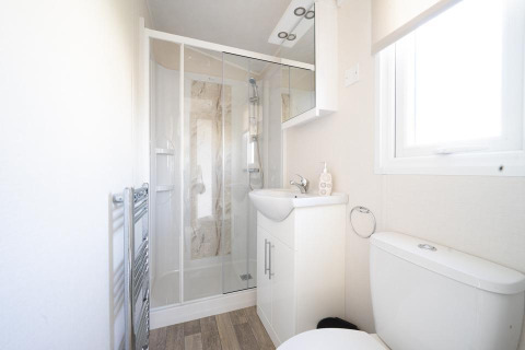 Bright, modern bathroom at Berkel lodge, Holiday park Aan de Maas, Netherlands, with shower and white decor.
