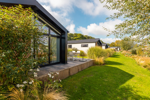 Lodge moderno «Berkel» en Holiday park Aan de Maas, Países Bajos, con terraza y jardines verdes.