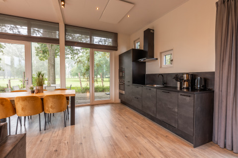 Moderne keuken en eetruimte in lodge 'Just Nature' bij Holiday park Aan de Maas, Nederland, met veel licht.