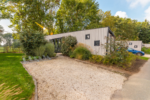 Moderno lodge Just Nature presso Holiday park Aan de Maas nei Paesi Bassi, circondato dal verde.