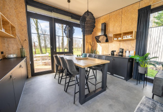 Moderne køkken og spiseområde med store vinduer i en lodge ved Holiday park Aan de Maas, Holland.