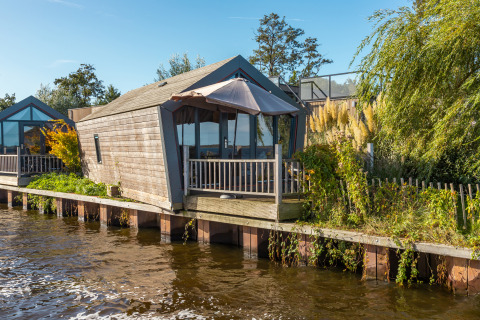 Tiny House «Havenzicht» on the waterfront at Holiday park De Wiedense Meren, Netherlands, on a sunny day.