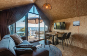 Cozy living room at Tiny House «Havenzicht» in the Netherlands, with lake view, patio, and modern decor.