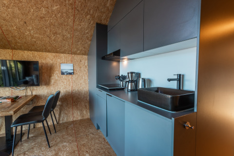Moderne køkken- og spisestueområde i Tiny House 'Havenzicht' på Holiday park De Wiedense Meren, Holland.