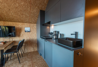 Modern kitchen and dining area inside Tiny House 'Havenzicht' at Holiday park De Wiedense Meren, Netherlands.