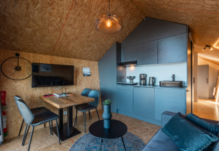 Modern tiny house interior with kitchen and lounge area at Holiday park De Wiedense Meren, Netherlands.