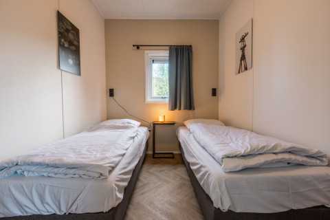 Deux lits simples avec literie blanche dans Holiday chalet Comfort, Holiday park De Wiedense Meren, Pays-Bas.