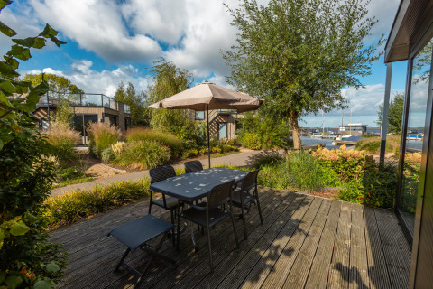 Terrasse extérieure avec table et chaises au parc De Wiedense Meren aux Pays-Bas, vue sur les bateaux.