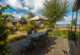 Terrasse extérieure avec table et chaises au parc De Wiedense Meren aux Pays-Bas, vue sur les bateaux.