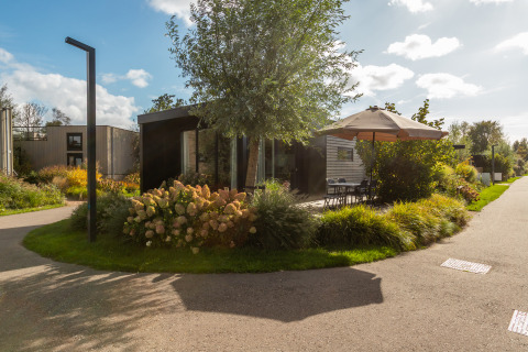 Chalet ensoleillé avec terrasse et parasol au Holiday Chalet Comfort à De Wiedense Meren, Pays-Bas.