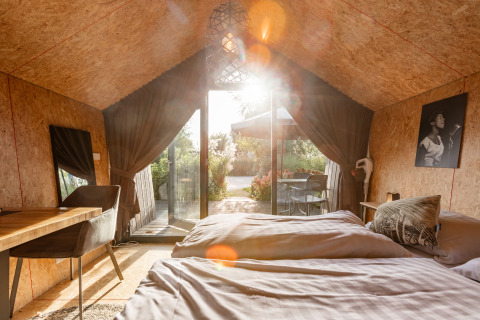 Solbeskinnet interiør i Tiny House på Holiday park De Wiedense Meren med udsigt til terrasse og natur.