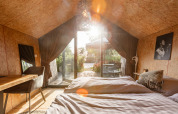 Intérieur lumineux d’une Tiny House au Holiday park De Wiedense Meren avec vue sur terrasse verdoyante.