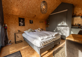 Tiny house moderna a De Wiedense Meren, Paesi Bassi, con letto matrimoniale, cucina e pareti in legno.