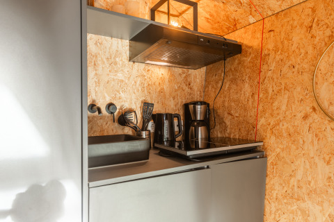 Piccola cucina del Tiny House presso Holiday park De Wiedense Meren, con piano cottura, lavello e caffettiera.