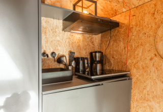 Piccola cucina del Tiny House presso Holiday park De Wiedense Meren, con piano cottura, lavello e caffettiera.