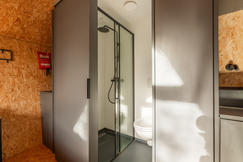 Moderne badeværelse i et tiny house ved Holiday park De Wiedense Meren i Holland med bruser og toilet.