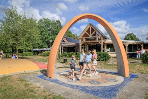 Bambini giocano sotto un grande arco nel parco giochi del parco vacanze Kaps, Overijssel, Paesi Bassi.