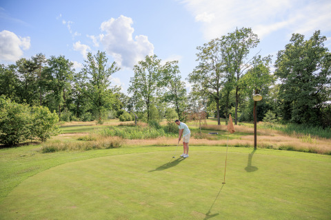 Ein Mann spielt Golf im Erholungspark Kaps in Overijssel, Niederlande, umgeben von grüner Natur.