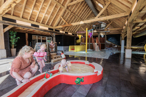 Innen-Wasserspielplatz im Ferienpark Kaps in Overijssel, Niederlande, Kinder spielen im Wasser.