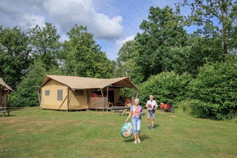 Coppia fuori dalla tenda safari 'Vogelkers' al Recreation park Kaps nei Paesi Bassi, nel verde.