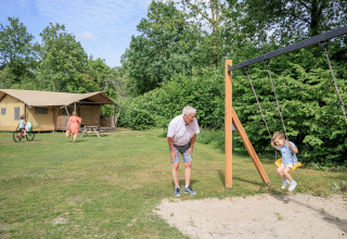 Tenda safari ‘Vogelkers’ al parco ricreativo Kaps nei Paesi Bassi, famiglia si gode le attività all’aperto.