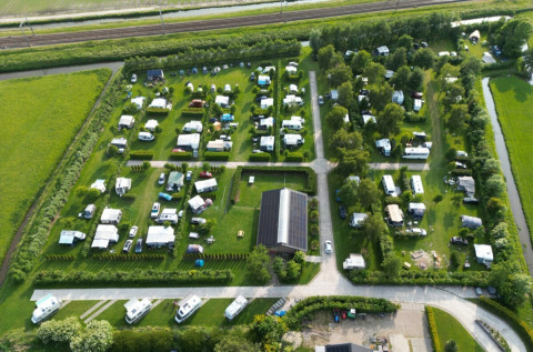 Aerial view of Campsite de Boerenzwaluw in North Holland, Netherlands, showing campers, caravans, and greenery.