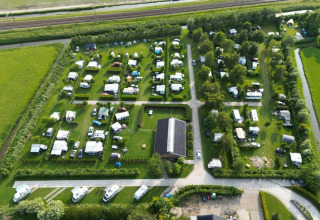 Luftfoto af campingpladsen de Boerenzwaluw i Nordholland, Holland, med campingvogne og grønt område.