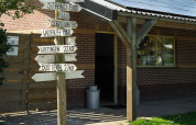 Wooden signpost with distances to local destinations at campsite de Boerenzwaluw, North Holland, Netherlands.