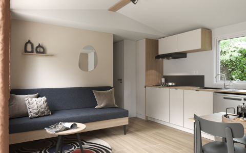 Soggiorno moderno e angolo cottura nel COTTAGE Premium del Campeggio Le Château, Francia, arredamento accogliente.
